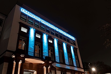 The historic Frankfurt UAS building shines brightly at night